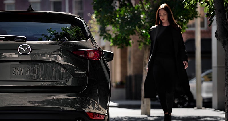 Woman walking on sidewalk next to a 2020 Mazda CX-5 | Bommarito Mazda St. Peters in St. Peters, MO